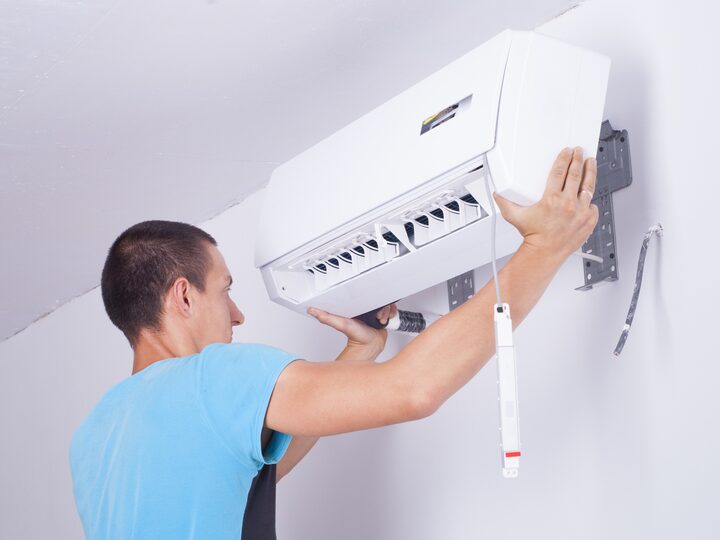 Tehnician ClimaTrust instalând un aparat de aer condiționat pe perete